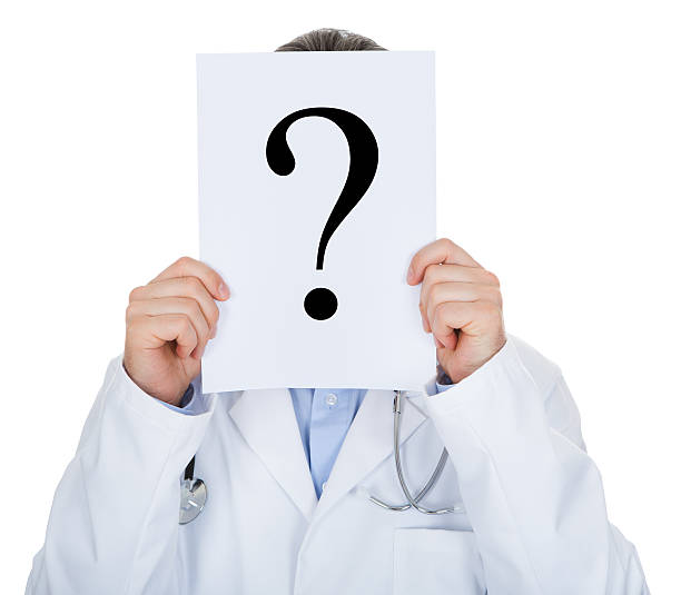 Portrait of doctor holding paper with question mark isolated on white background